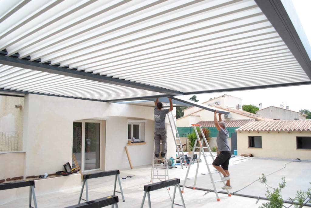 2 techniciens PGI Habitat, installe une pergola bioclimatique