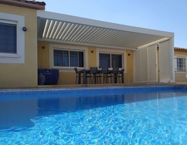 pergola bioclimatique en aluminium blanc adossée à deux façade et persienne latérale