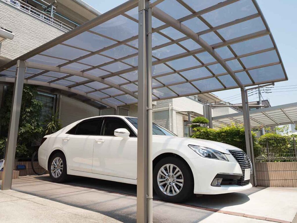 Berline abrité des intempéries par un carport cintré moderne