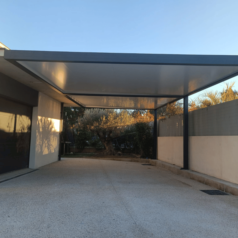 Carport double en aluminium avec trois poteaux.